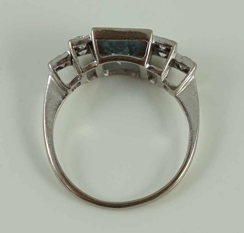 An 18ct white gold oval cut aquamarine and six stone diamond cluster set dress ring